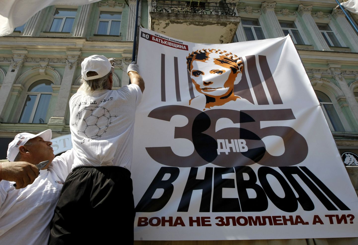 Tõmošenko toetajad Kiievi kesklinnas asuvas telklaagris naist kujutavat plakatit üles panemas.