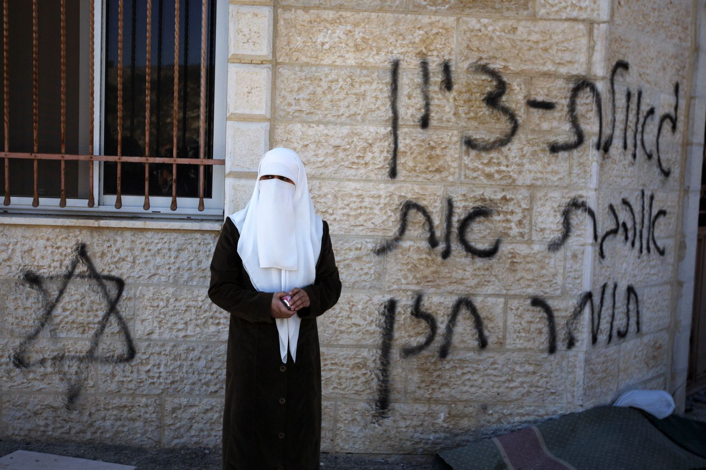 Palestiina naine Läänekaldal täissoditud mošee kõrval.