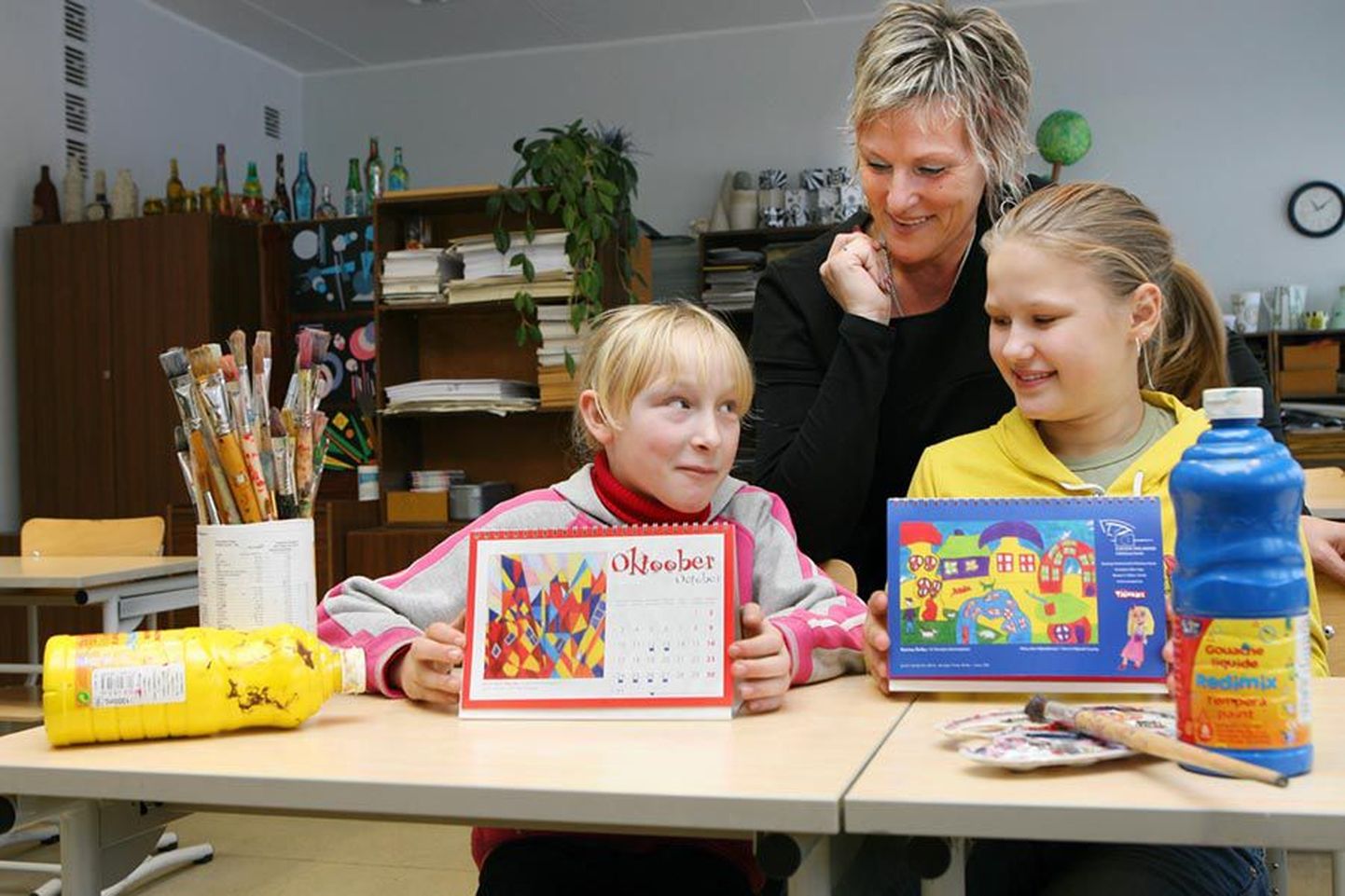 Kirsi Mari Mändla neljandast ja Karina Boiko viiendast klassist rõõmustavad kunstiõpetaja Küllike Bärengrubi tunnis tehtud piltide edu üle väga.