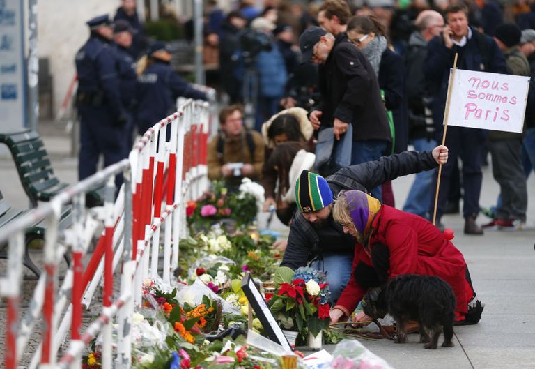 Возле французского посольства в Берлине люди возлагают цветы и свечи.