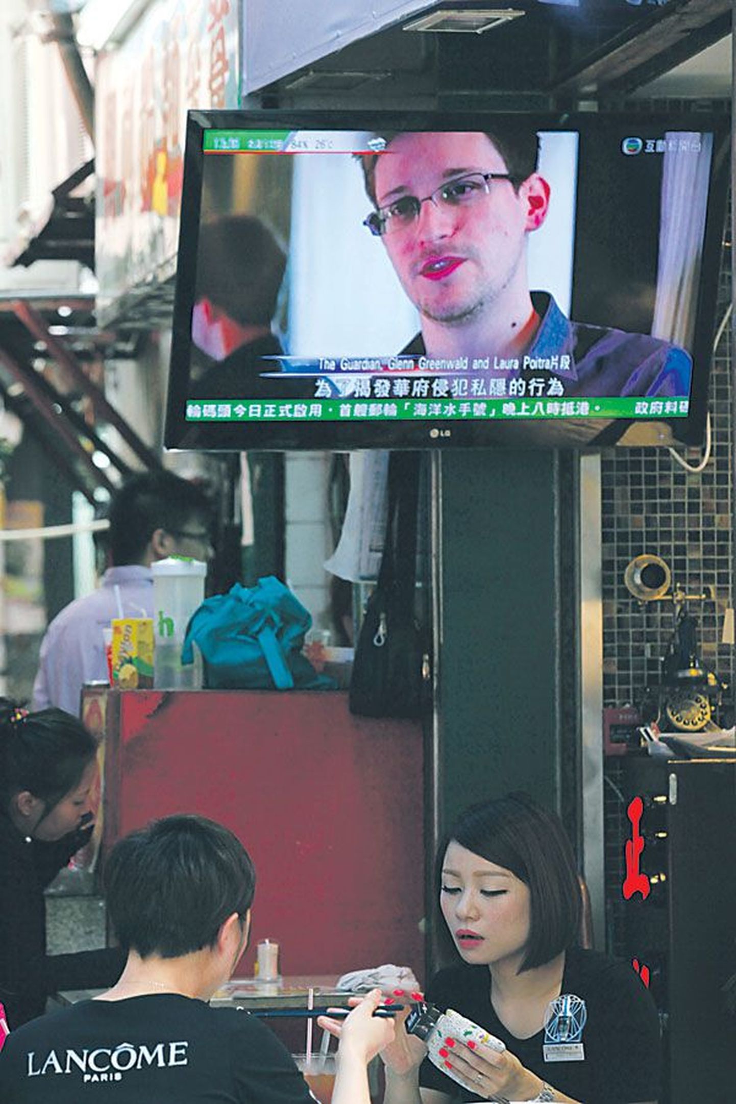 На ТВ-экране одного из ресторанов Гонконга транслируются новости, в кадре — Эдвард Сноуден. 12 июня 2013 года его местонахождение оставалось неизвестным.