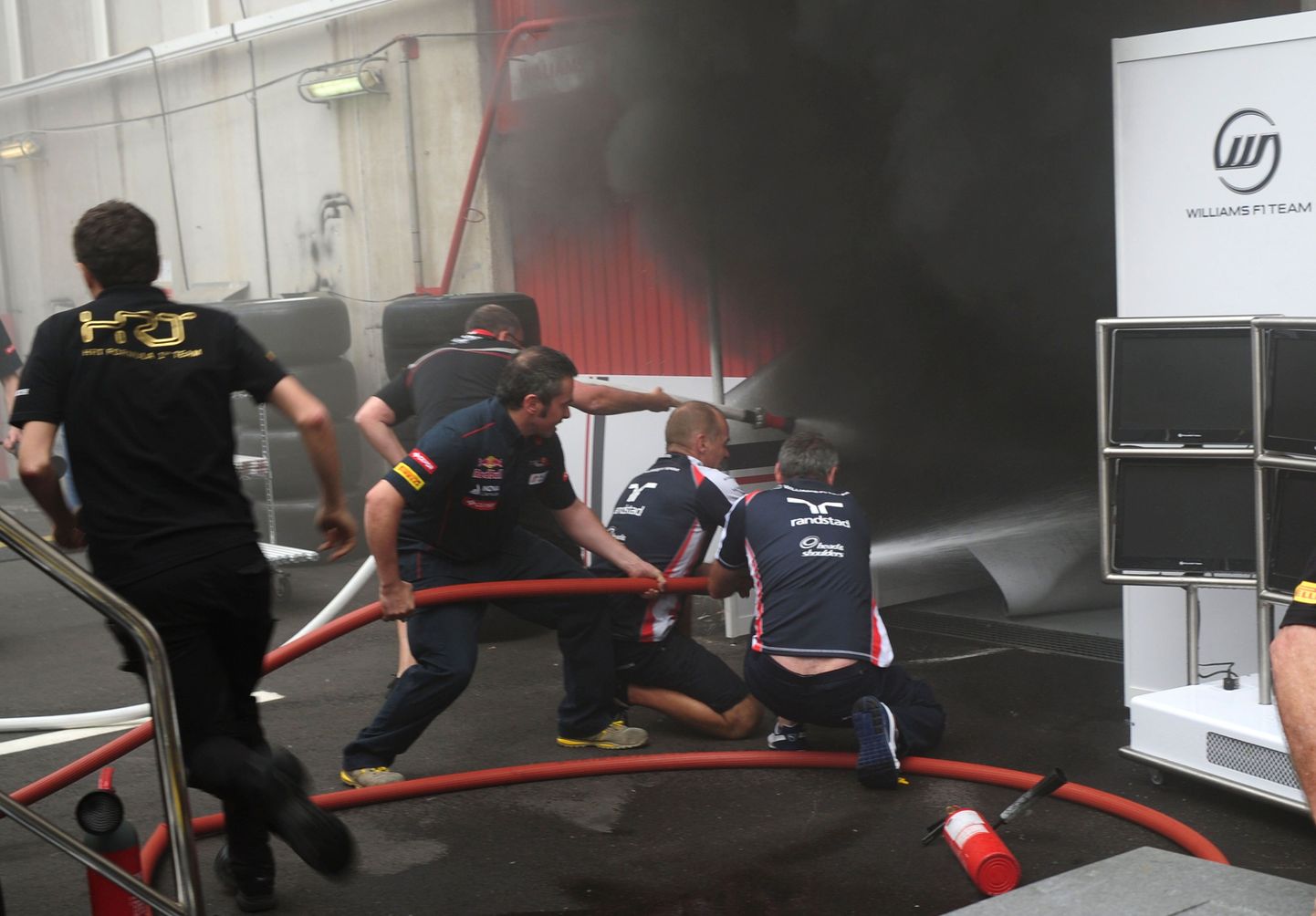 Vormel-1 meeskondade töötajad kustutavad Williamsi garaažis puhkenud tulekahju.