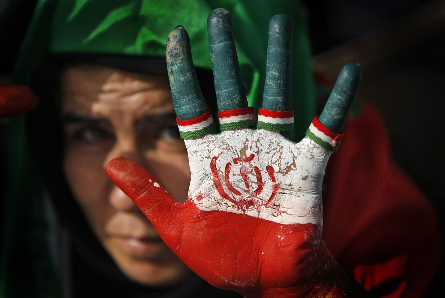 Naine näitab peopesale joonistatud Iraani lippu.