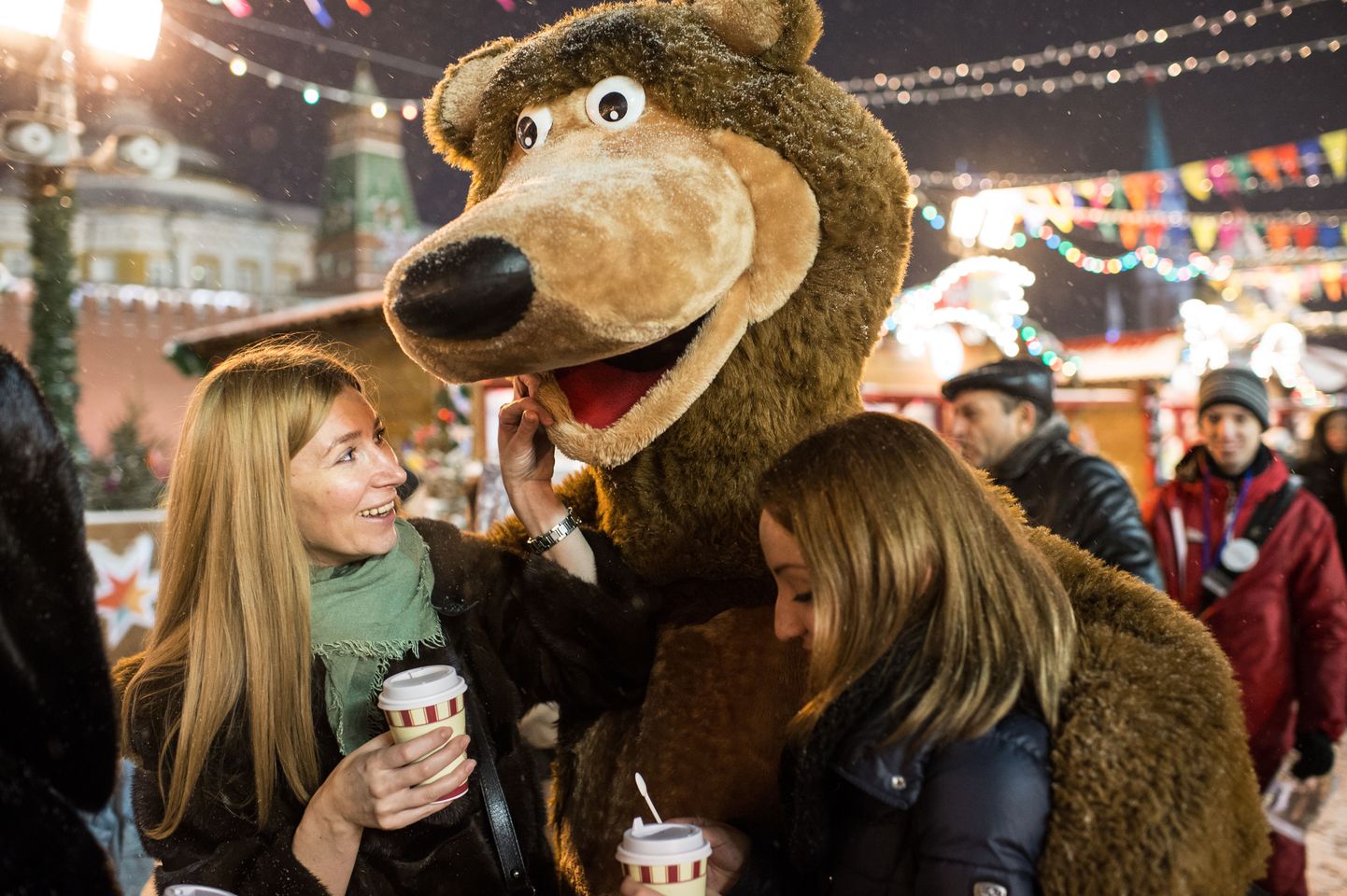 Turistid Moskva punasel väljakul poseerimas koos karu kostüümis maskotiga.