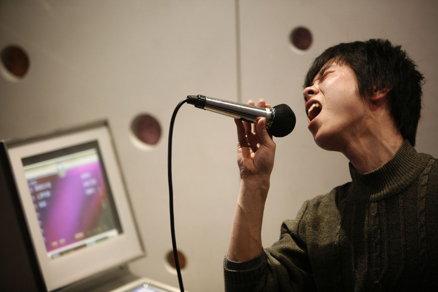 Laulmine võib aidata pärast insulti kiiremini kõnelema hakata. Pildil Shanghai karaokebaaris esinev noormees.