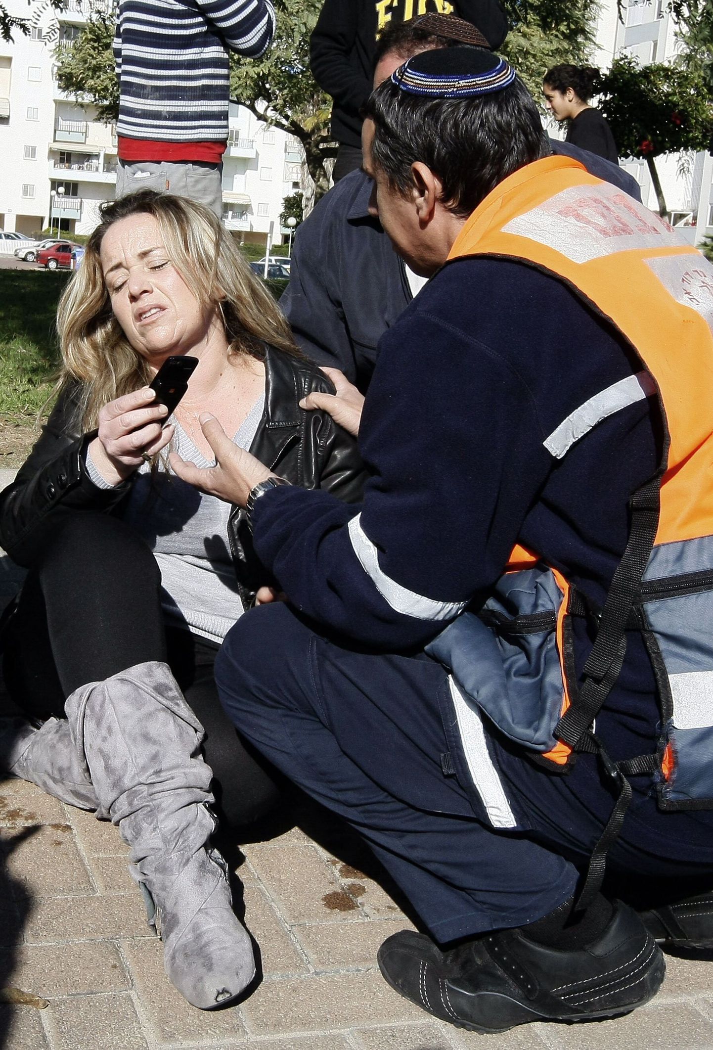 Израильские медики оказывают помощь женщине, пострадавшей в результате взрыва ракеты.