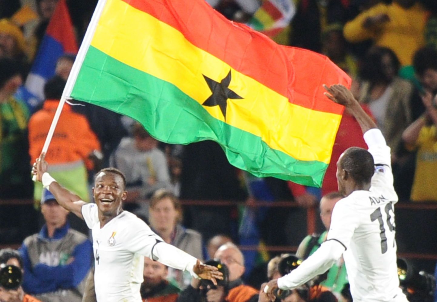 Футболист сборной Ганы празднует победу с флагом своей страны в руках (ЧМ-2010).