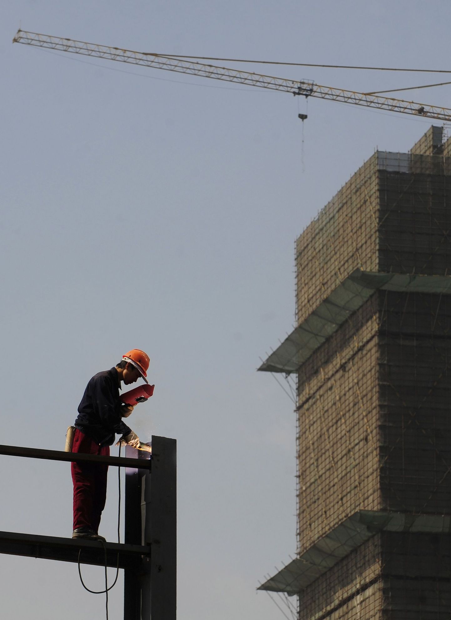 Ehitustööline Hiina Anhui provintsis Hefeis kinnisvaraprojekti reklaami alust keevitamas.