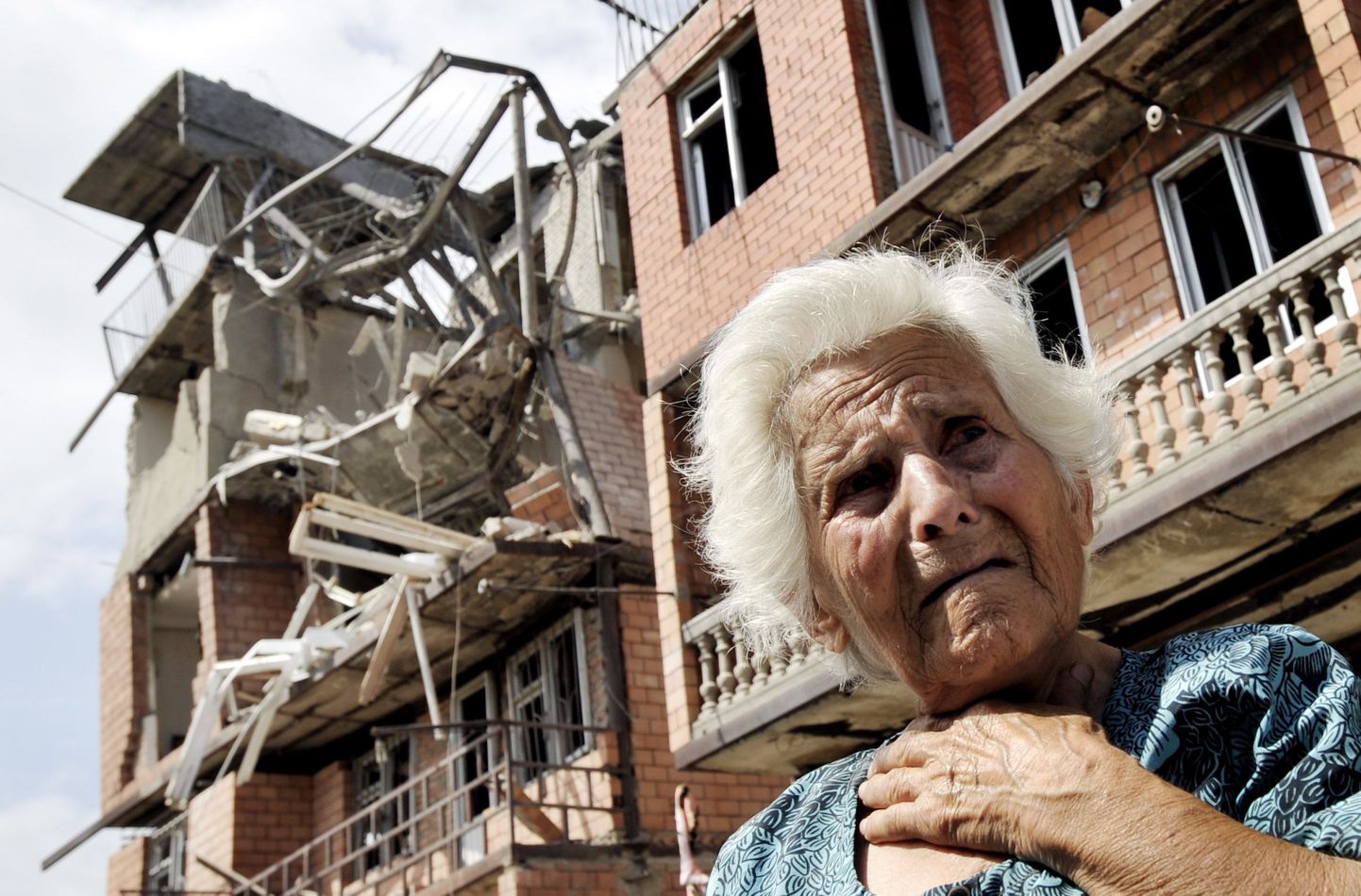 Gruusia naine nutmas täna oma purustatud koduamaja ees Goris.