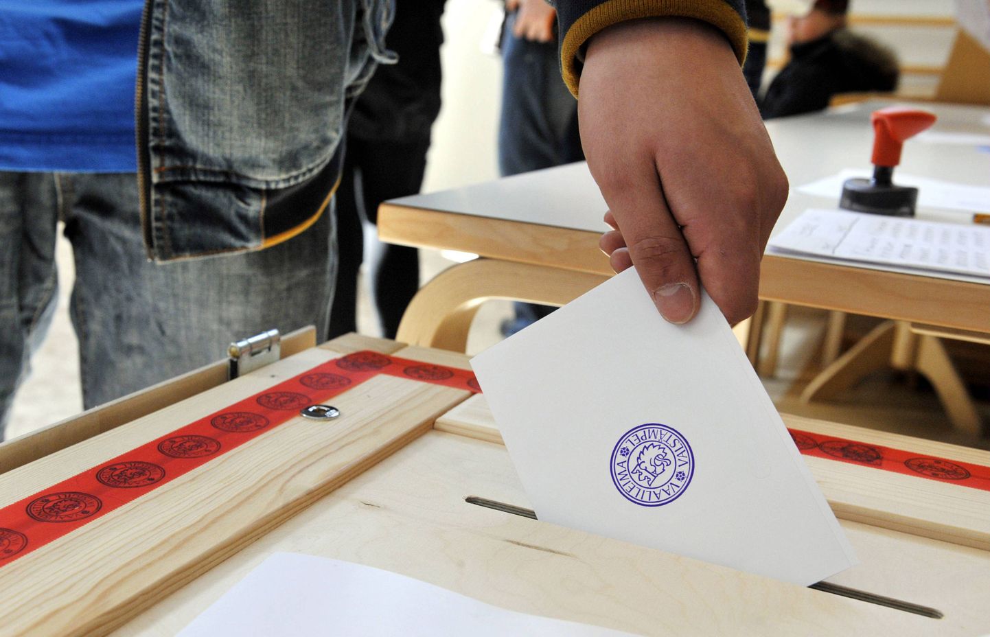 Hääleõiguslik soomlane pistab valimissedeli kasti.