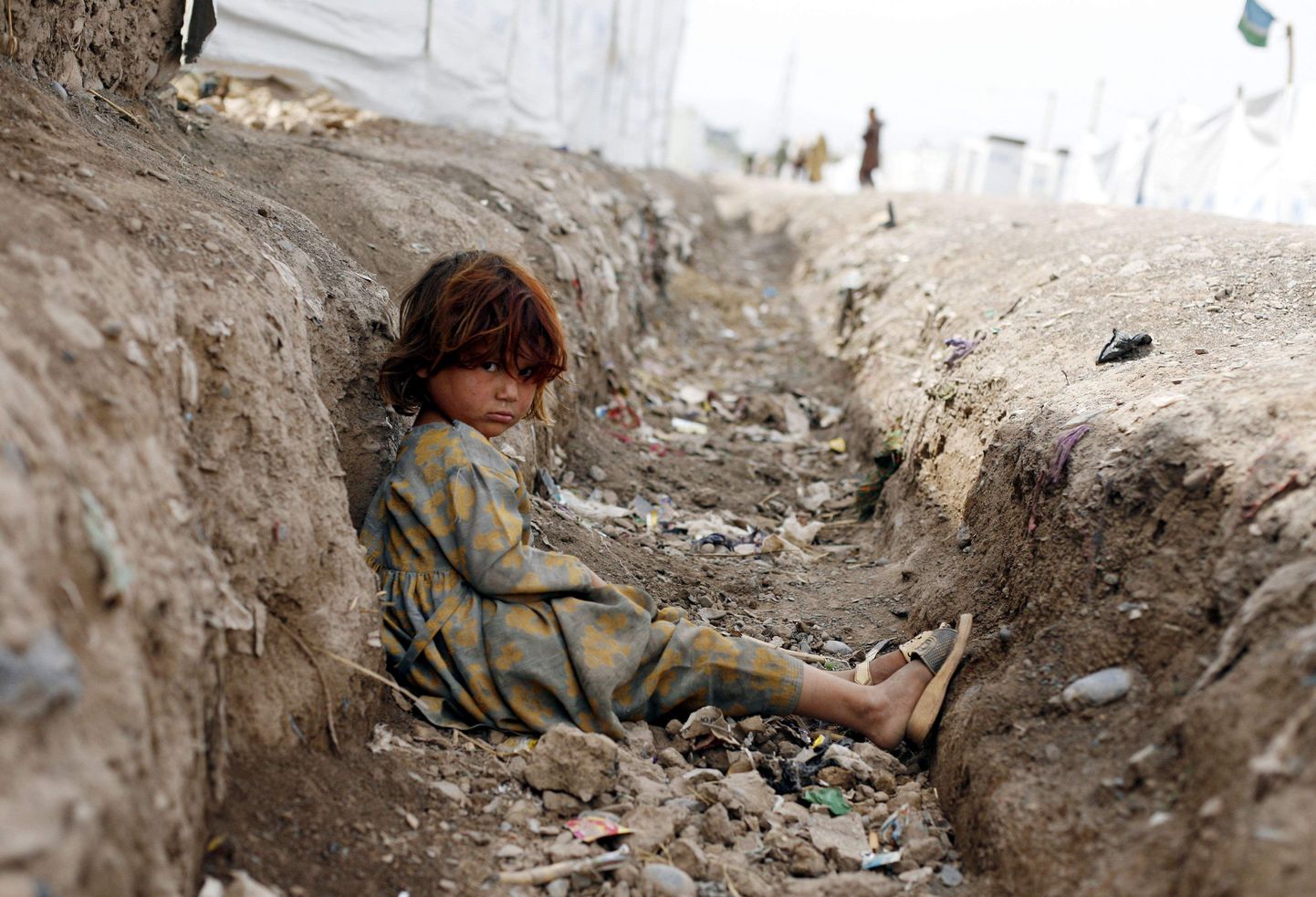Kuivenduskraavis mängiv laps on üks Pakistani põgenikest, kes elavad ajutistes telklaagrites.