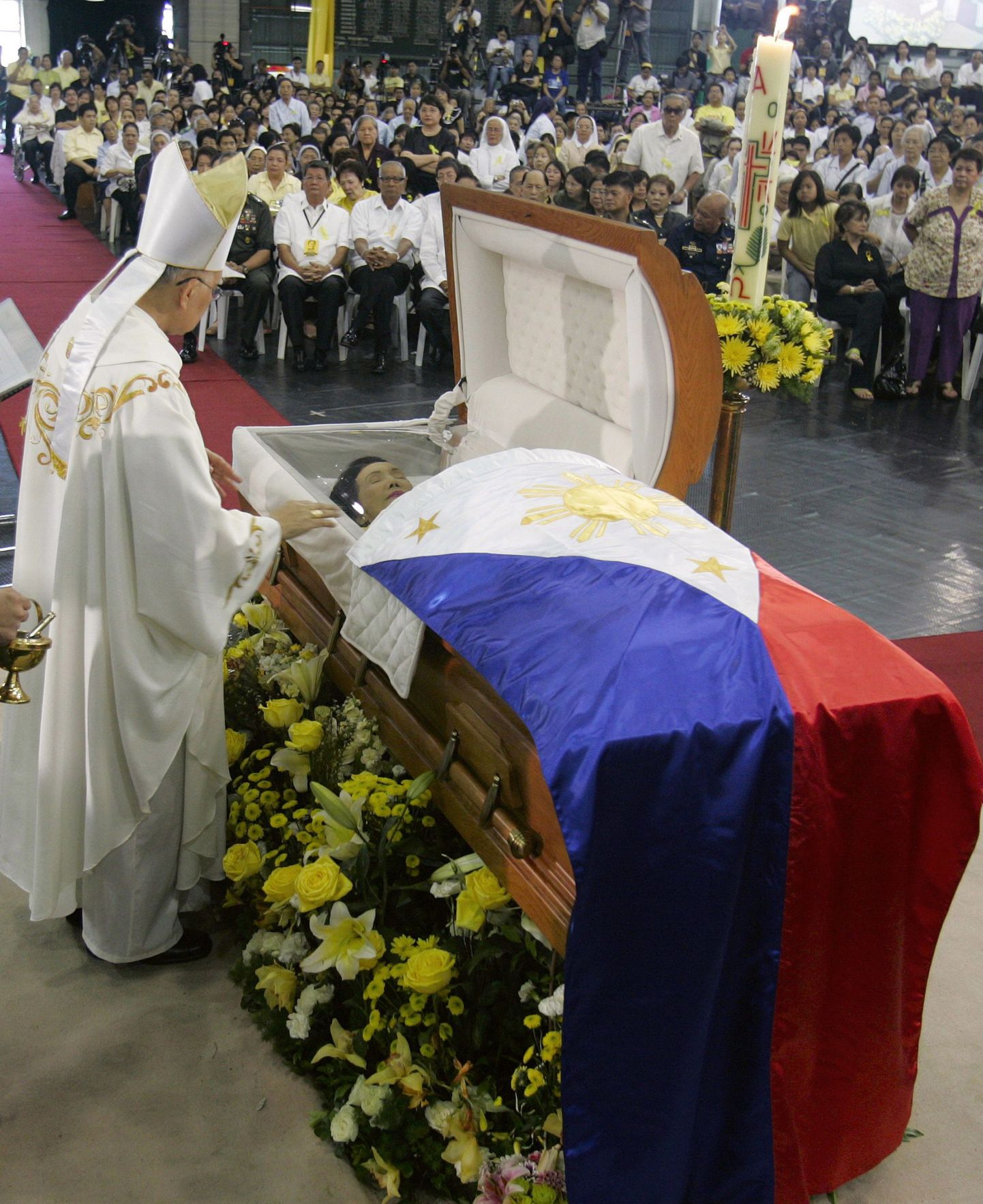 Aquino kirst toodi selleks, et rahvas temaga hüvasti jätta saaks, La Salle kooli võimlasse. Pildil palvetab kunagise riigipea eest Filipiinide piiskop Angel Lagdameo.