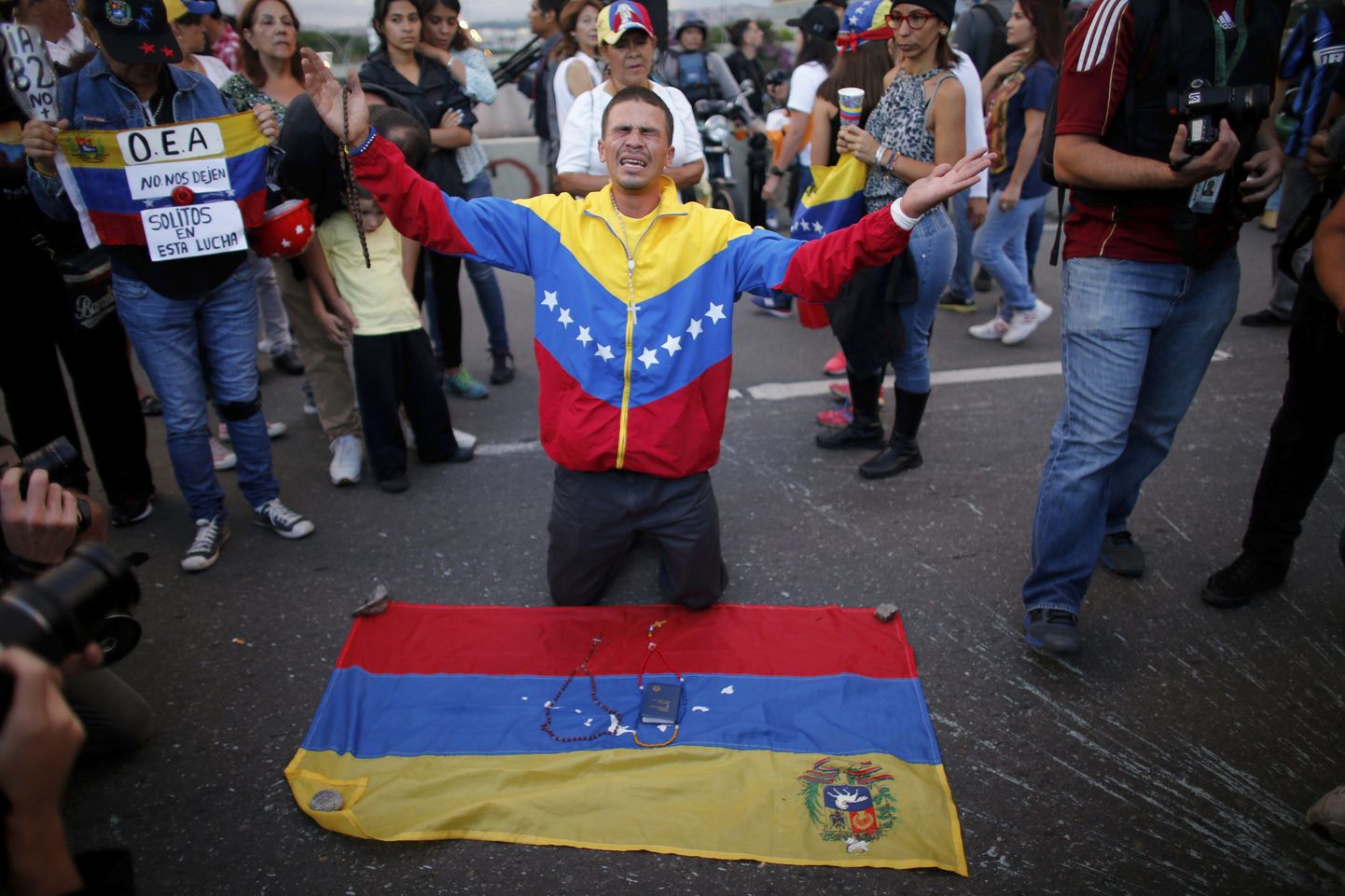 Venezuela trikoloori kandev mees leinab meeleavaldustel tapetud tudengit.