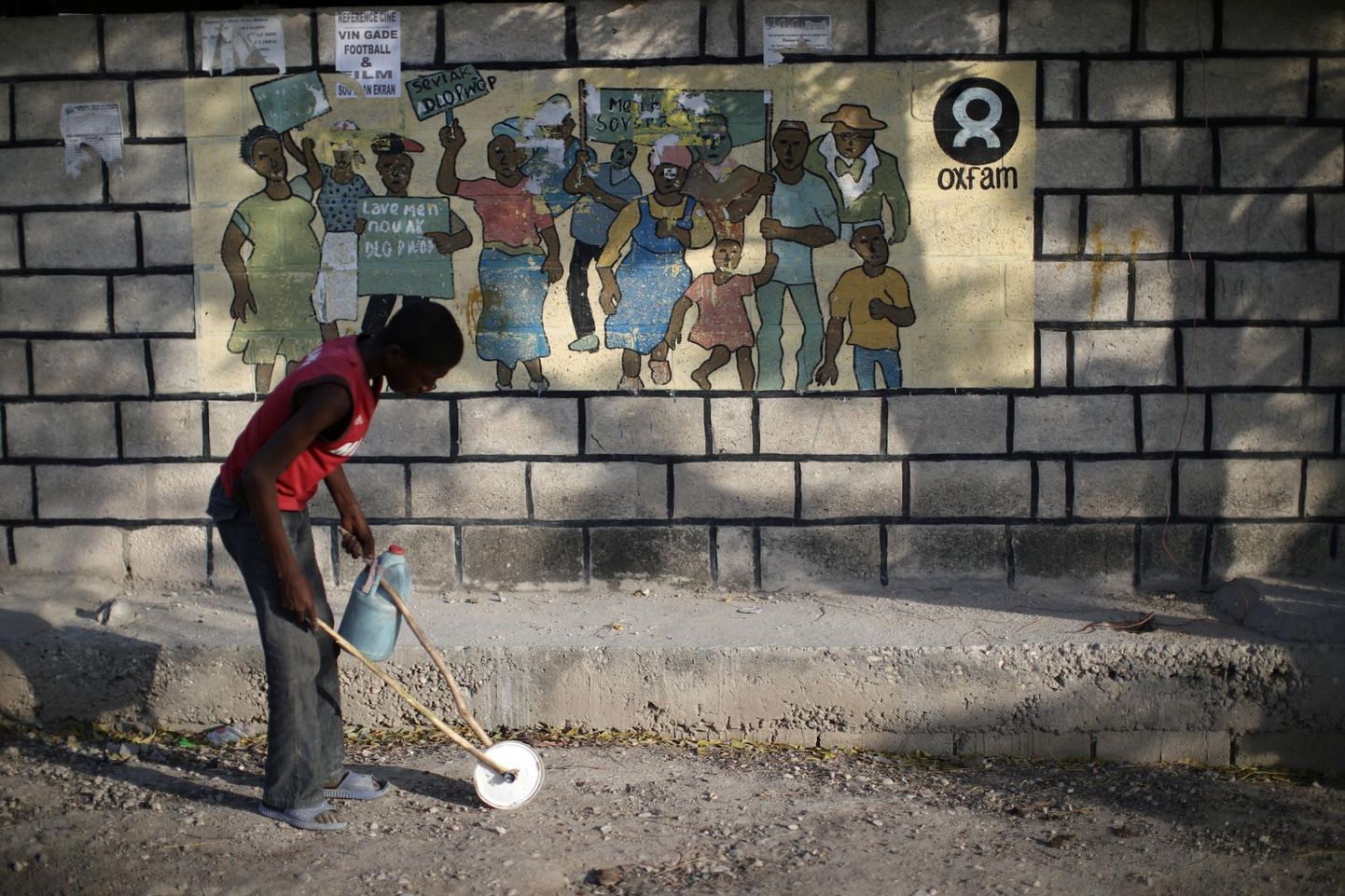 Poiss mängib abiorganisatsiooni Oxfam sildi ees Haiti pealinna Port-au-Prince’i laagris, kus elavad 2010. aasta maavärinas kodu kaotanud inimesed.