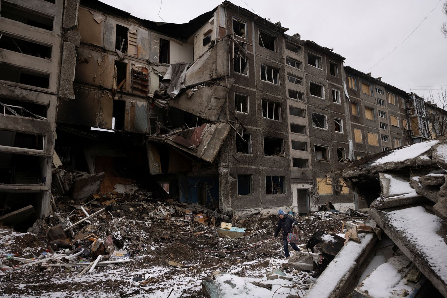 Женщина проходит мимо жилых домов, разрушенных в результате российского ракетного удара в Селидово под Авдеевкой в ходе агрессии России против Украины, 19 февраля 2024 года.