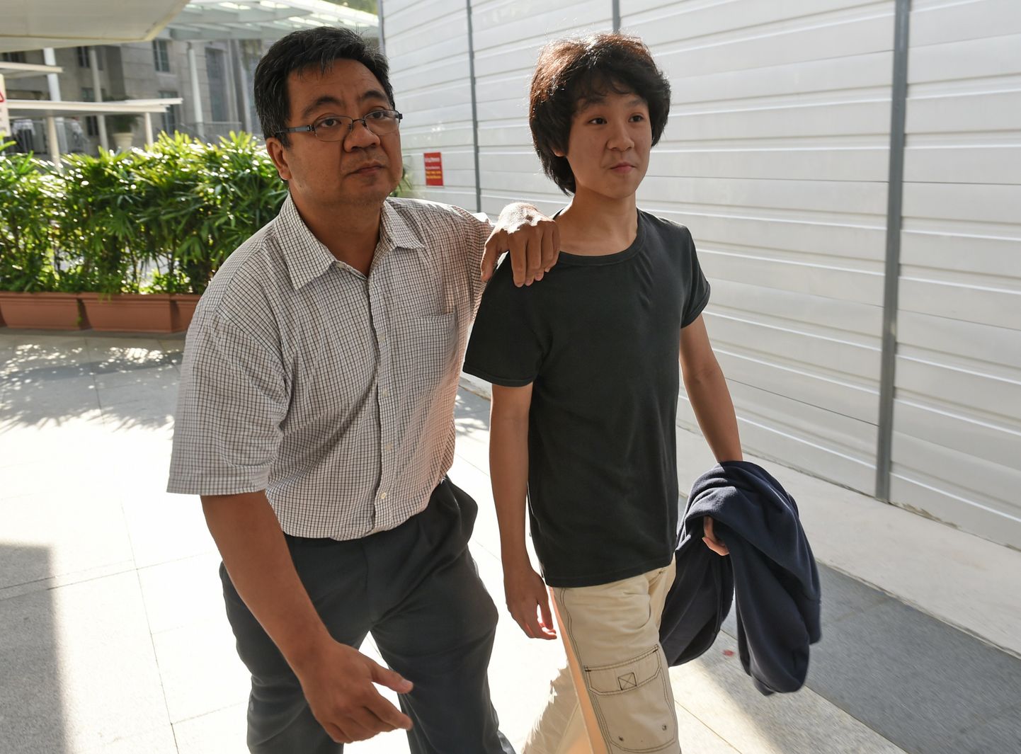 16-aastane Amos Yee Singapuri asutajat ja kristlust kritiseerinud video pärast isaga kohtusse suundumas.