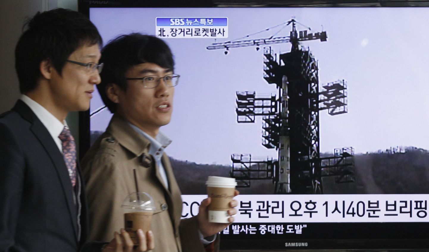 Lõunakorealased teleriekraani ees, kust on näha Põhja-Korea raketistarti.
