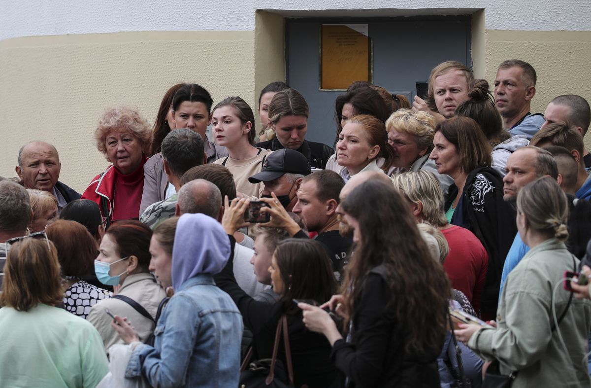 Minskas iedzīvotāji uzmanīgi klausās informāciju no pagaidu aizturēšanas centra, lai uzzinātu par savu protestos aizturēto tuvinieku likteni
