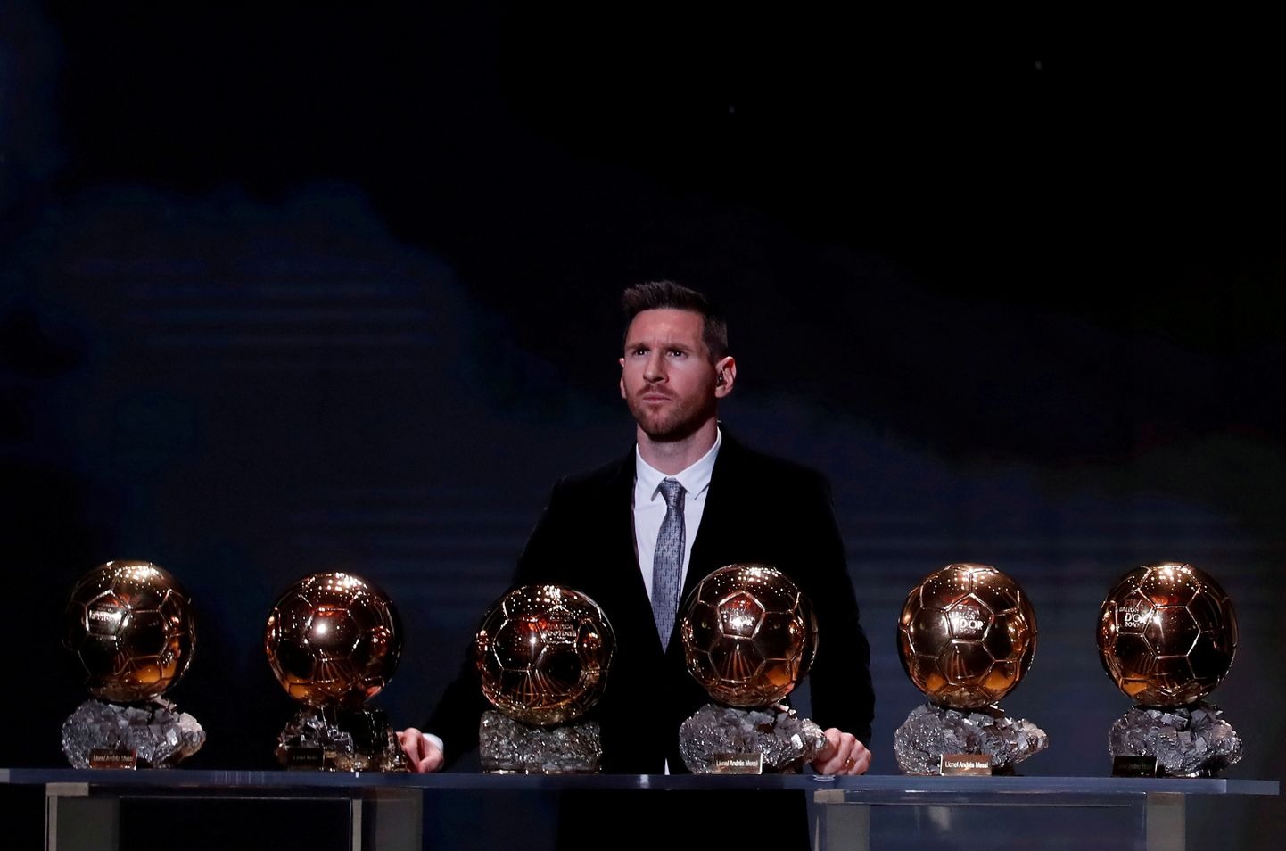Lionel Messi koos maailma parimale mängijale kuuluvate trofeedega.
