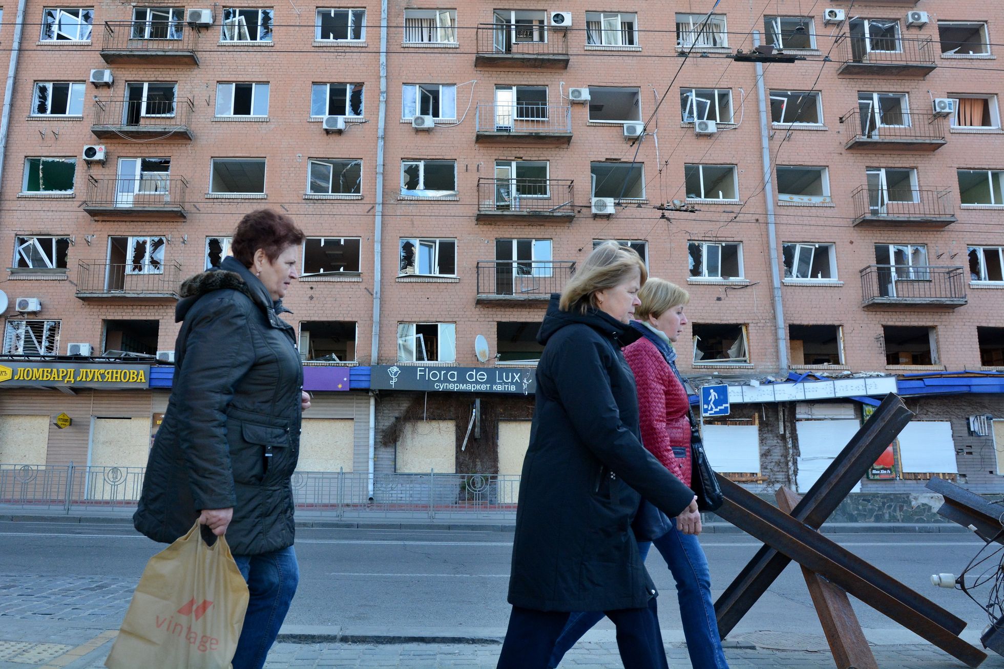 Inimesed mööduvad Vene raketirünnakus purustatud akendega majast Kiievis.
