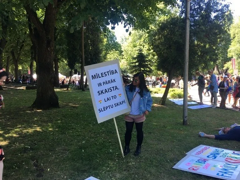 Gājiena dalībniece ar plakātu