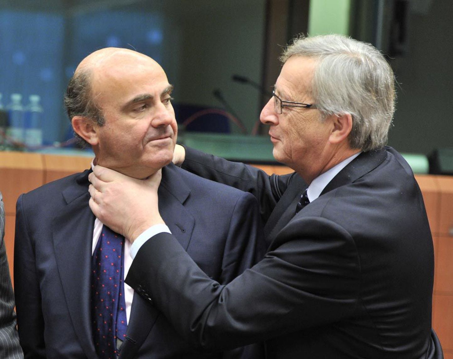 Hispaania rahandusminister Luis de Guindos (vasakul) ja eurogrupi juht Jean-Claude Juncker enne eurotsooni rahandusministrite kohtumist. Pärast esialgset sõbralikku kallistust näitas Juncker piltlikult, et Hispaania on täbaras seisus.