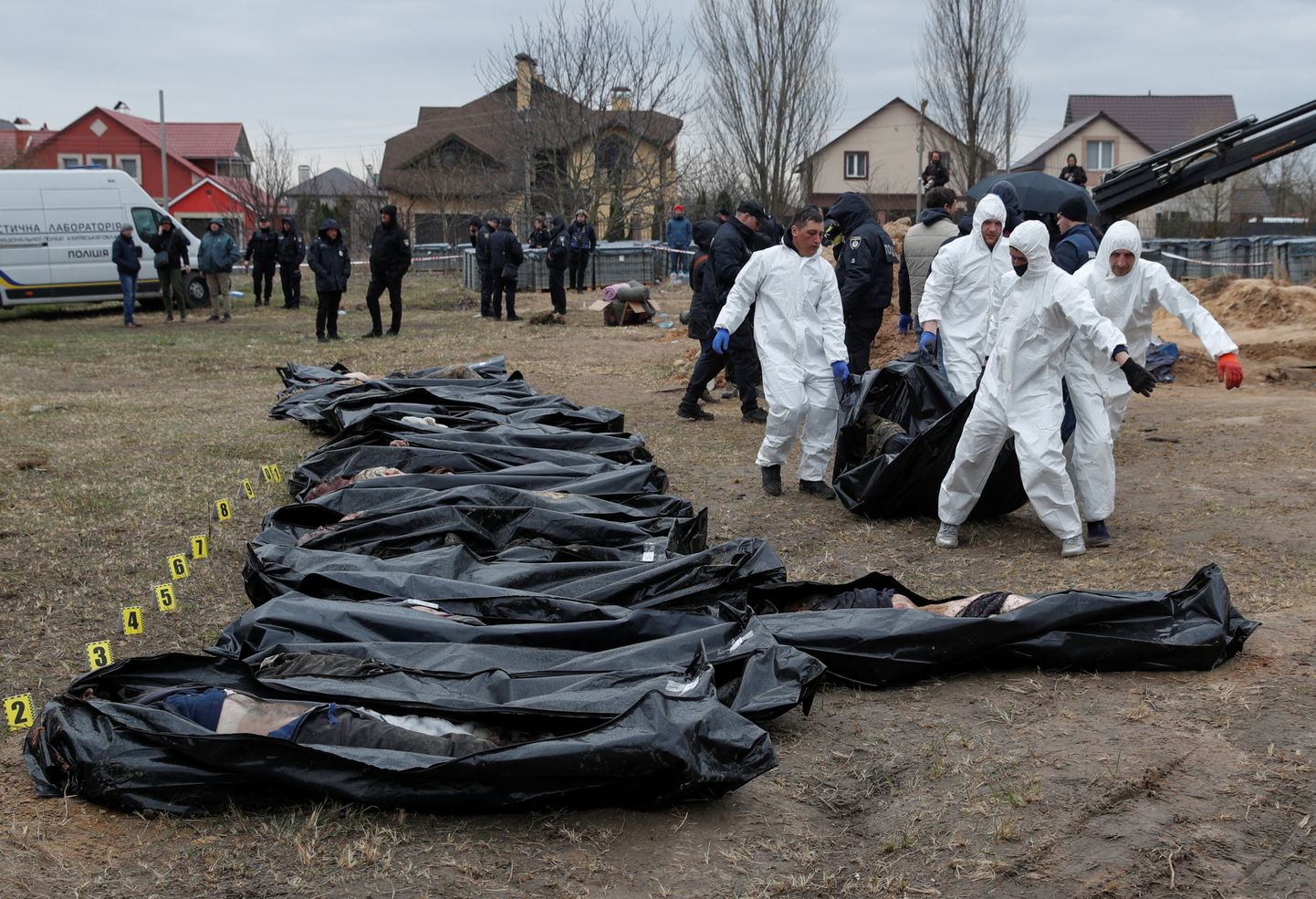 Судмедэксперты эксгумируют тела мирных жителей, которые были убиты во время вторжения российских войск, а затем похоронены в братской могиле в городе Буча под Киевом.