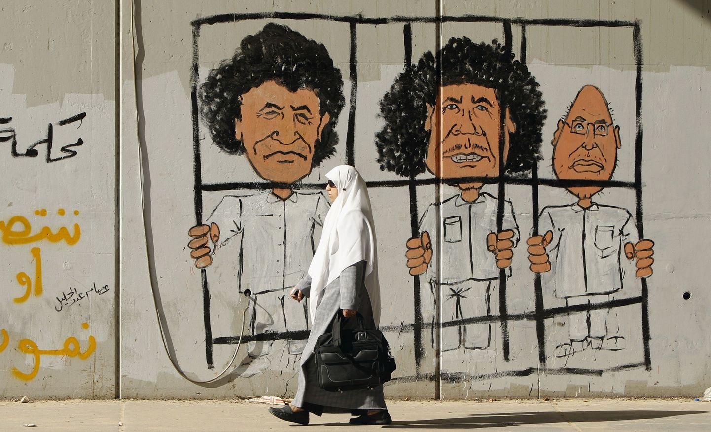 Tripolis oleval grafitil on kujutatud Muammar Gaddafit (keskel), tema poega Saif al-Islami (paremal) ja endist luurejuhti Abdullah Al-Senussit.