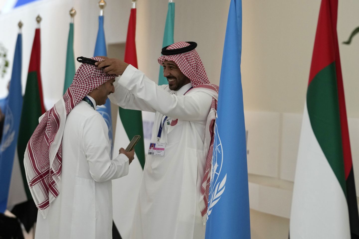 Üks Dubais peetaval ÜRO kliimatippkohtumisel COP28 viibijaist kohendab teise ghutrat.
