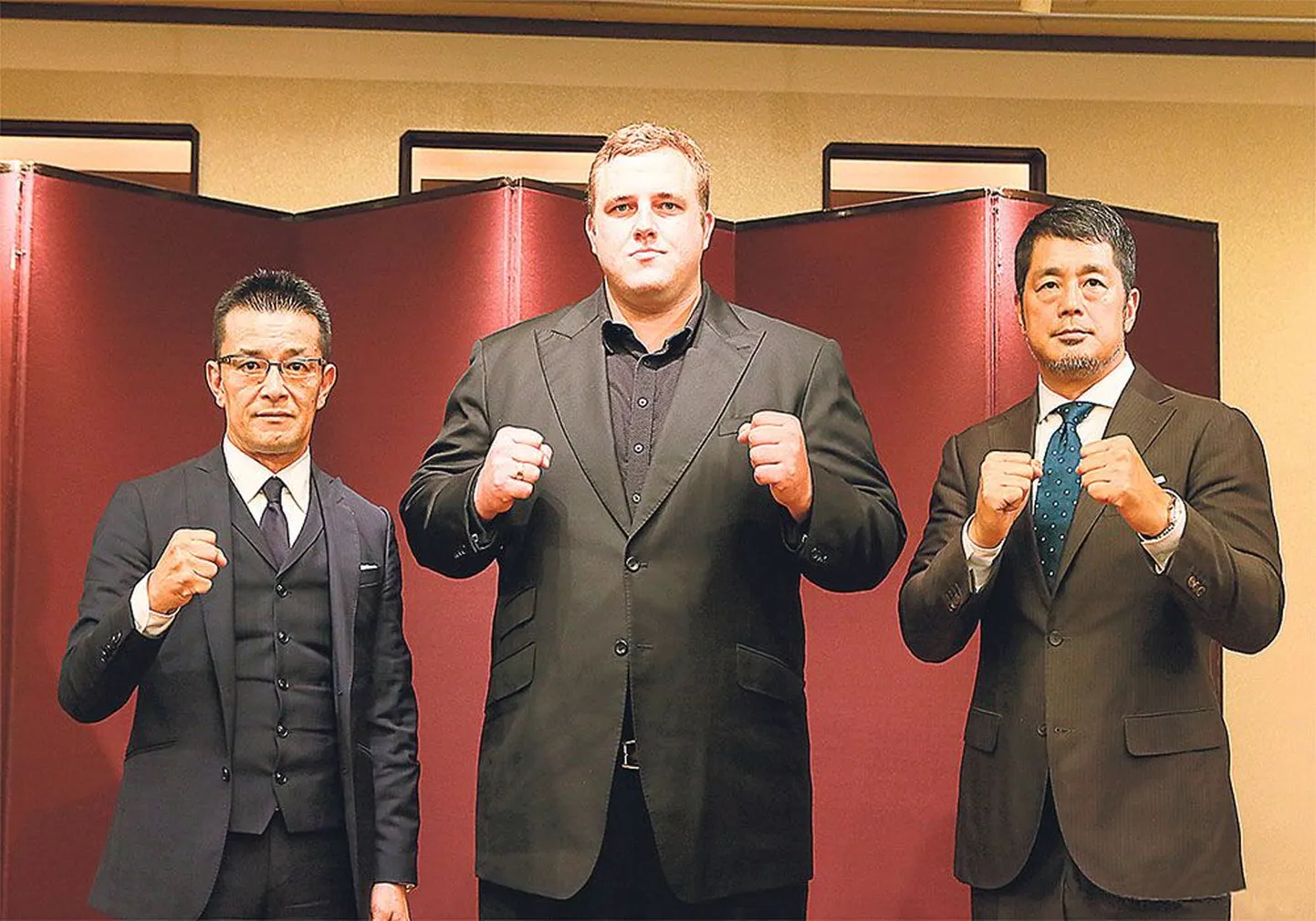 Кайдо Хёэвельсон готов к новому испытанию. Его охраняют руководители спортивной федерации Rizin Fighting Federation Нобуяки 
Сакакибара (слева) и Нобухико Такада (справа).