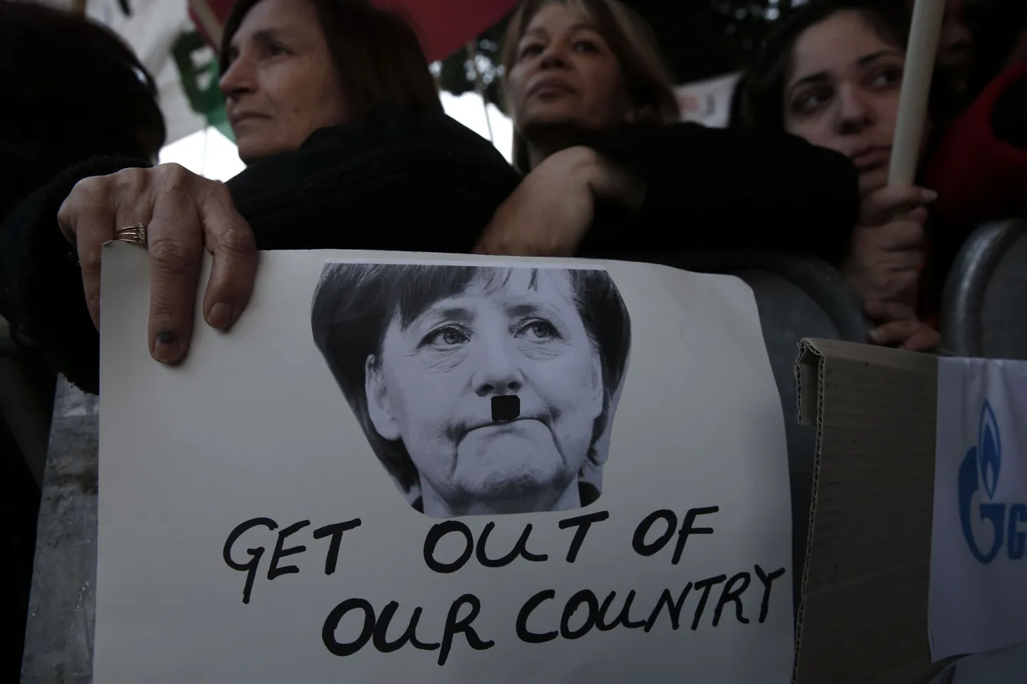 Küprose parlament tõrjus teisipäeval ühehäälselt hoiuste maksustamise tingimuse päästepaketile. Fotol protestijad Angela Merkeli plakatiga, millel viimast on kujutatud Adolf Hitleri vuntsidega.