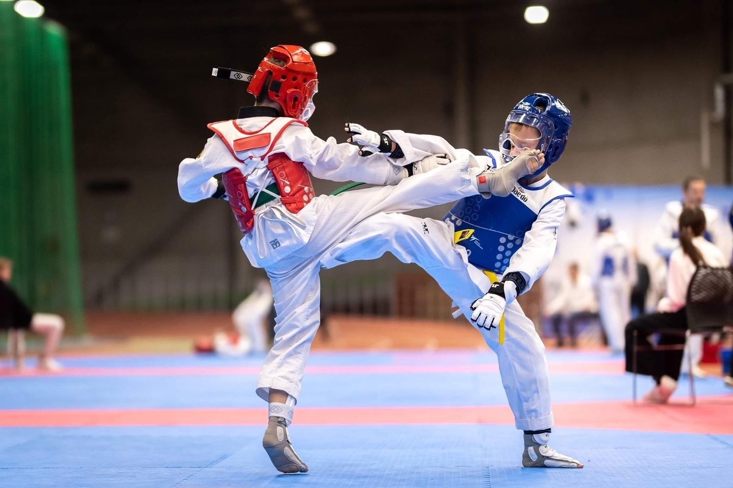 Jalahoopide eest näkku kaitsevad noori taekwondo-sportlasi kiiver ja visiir.