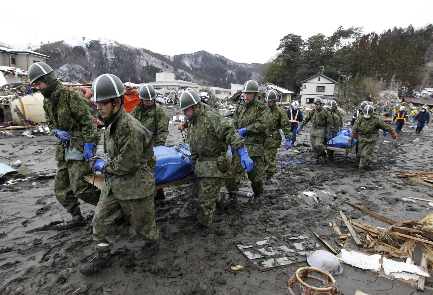 Jaapani sõjaväelased täna Yamadamachis kandmas tsunamis hukkunute surnukehi.