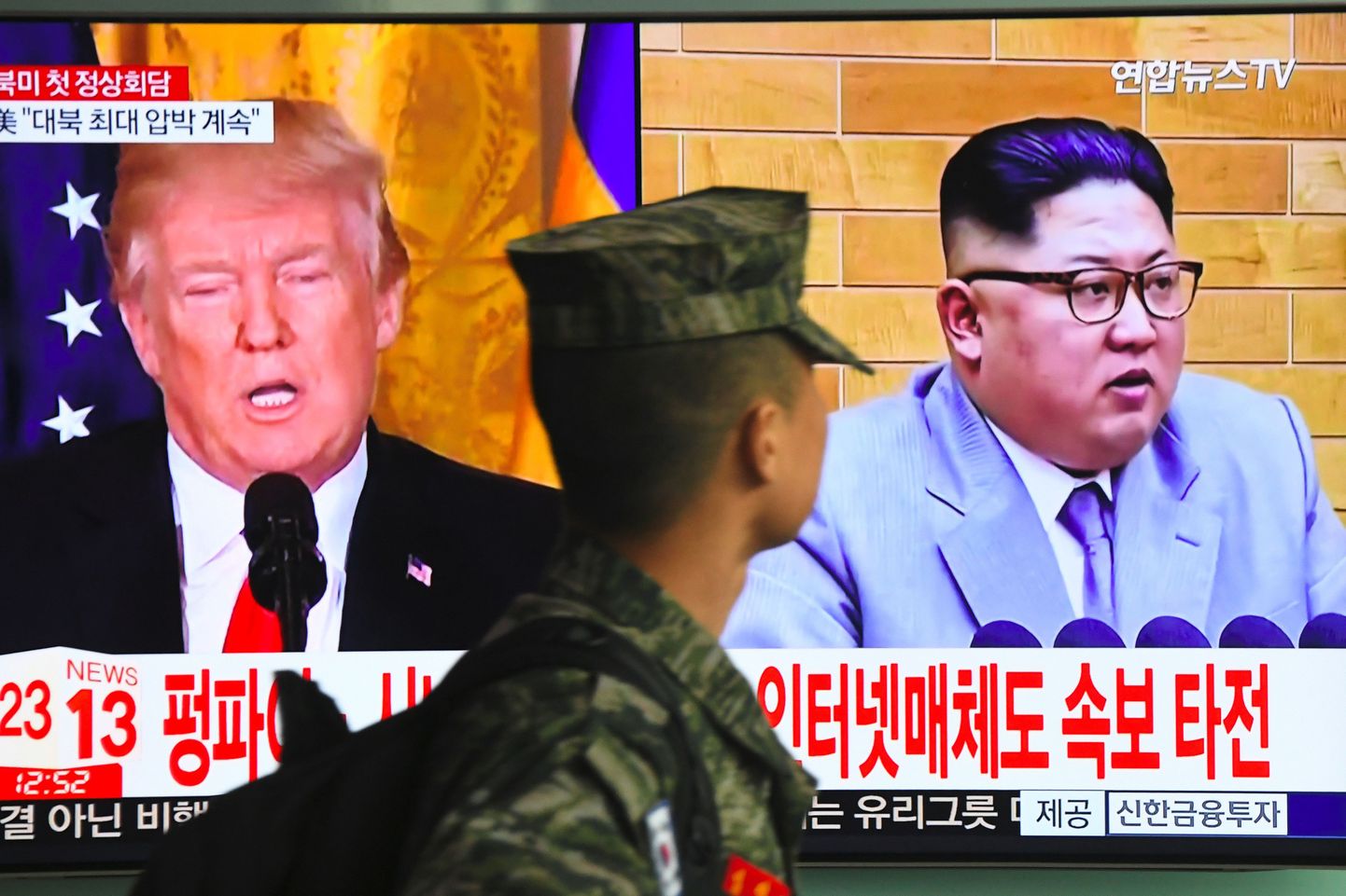 Lõuna-Korea sõdur möödumas ekraanist, millel teatatakse Donald Trumpi ja Kim Jong-uni kohtumisest.