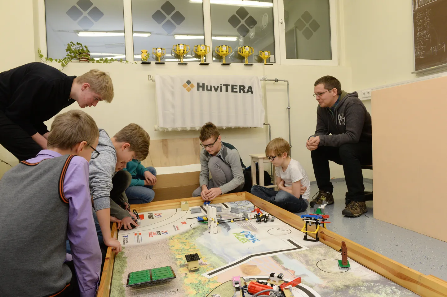 Huvitera robootikahuvilised andsid kolmapäeva õhtul robotile veel viimast lihvi. Pildil Tartu erakooli 6. klassi õpilane Georg Järvis (vasakult), Variku kooli 5. klassi õpilane Ragnar Reino, ringi kaasjuhendaja ja Veeriku kooli 9. klassi õpilane Koit Krusberg (mustas), Tamme kooli 6. klassi õpilane Joosep Juhani, Herbert Masingu kooli 4. klassi õpilane Mattias Volt ja robootikaringi juhendaja Taavi Duvin.