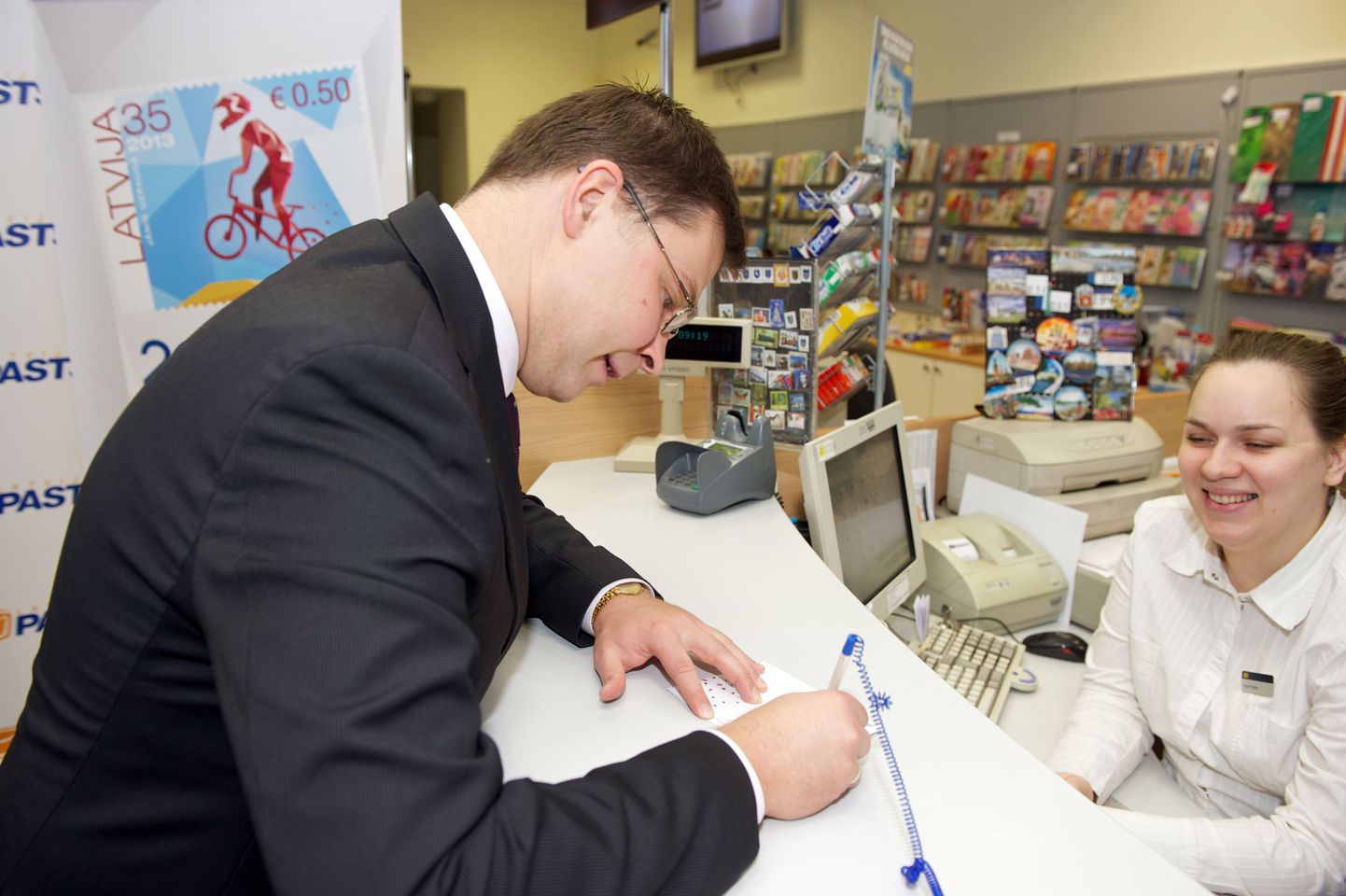 Läti peaminister Valdis Dombrovskis jaanuari lõpus esimese lati kõrval ka euroraha väärtust kandva esimese margi esitlusel kaarti kirjutamas.