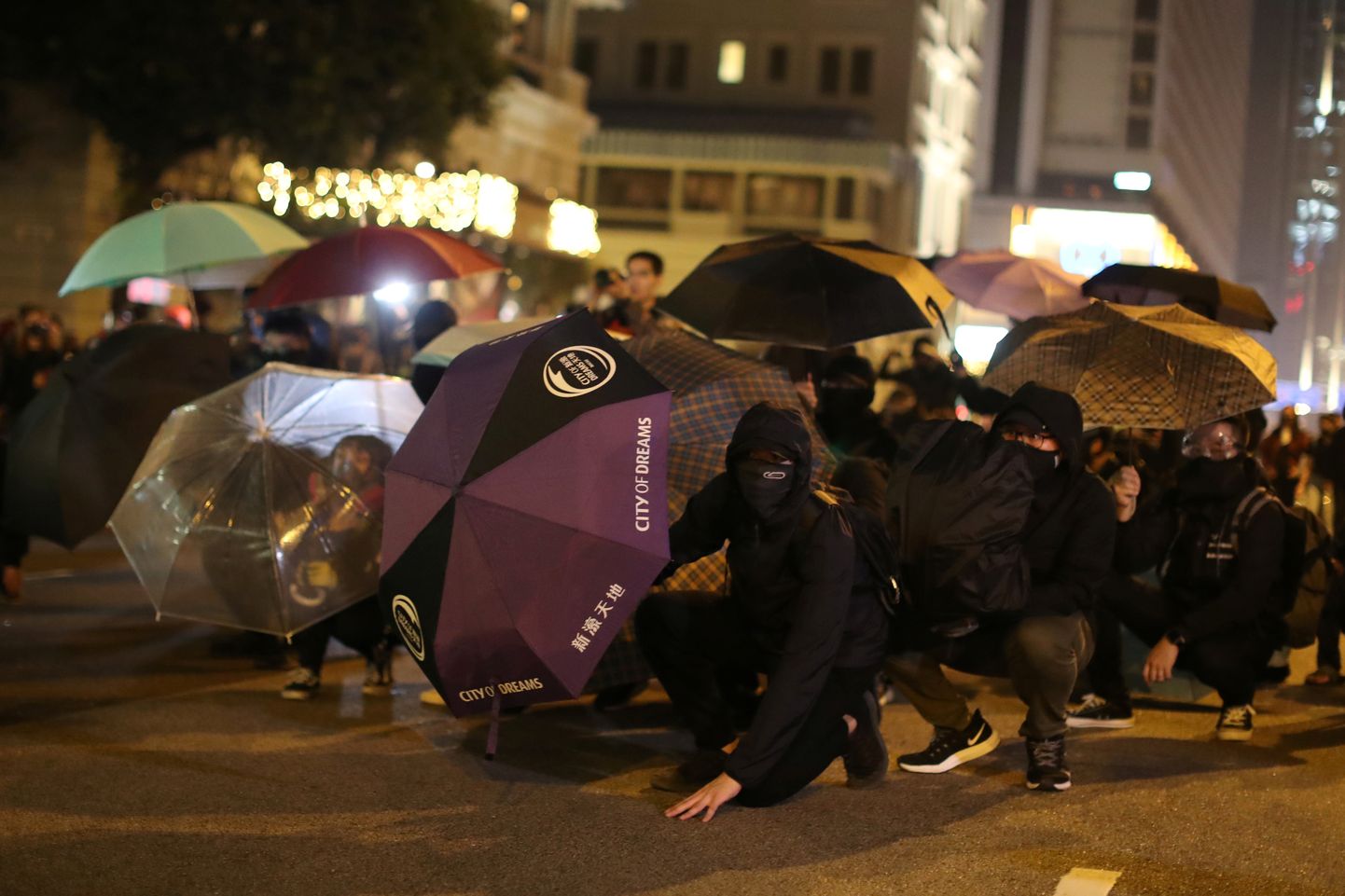 Hongkongi meeleavaldajad kaitsmas end 24. detsembril märulipolitseinike pisargaasi eest.