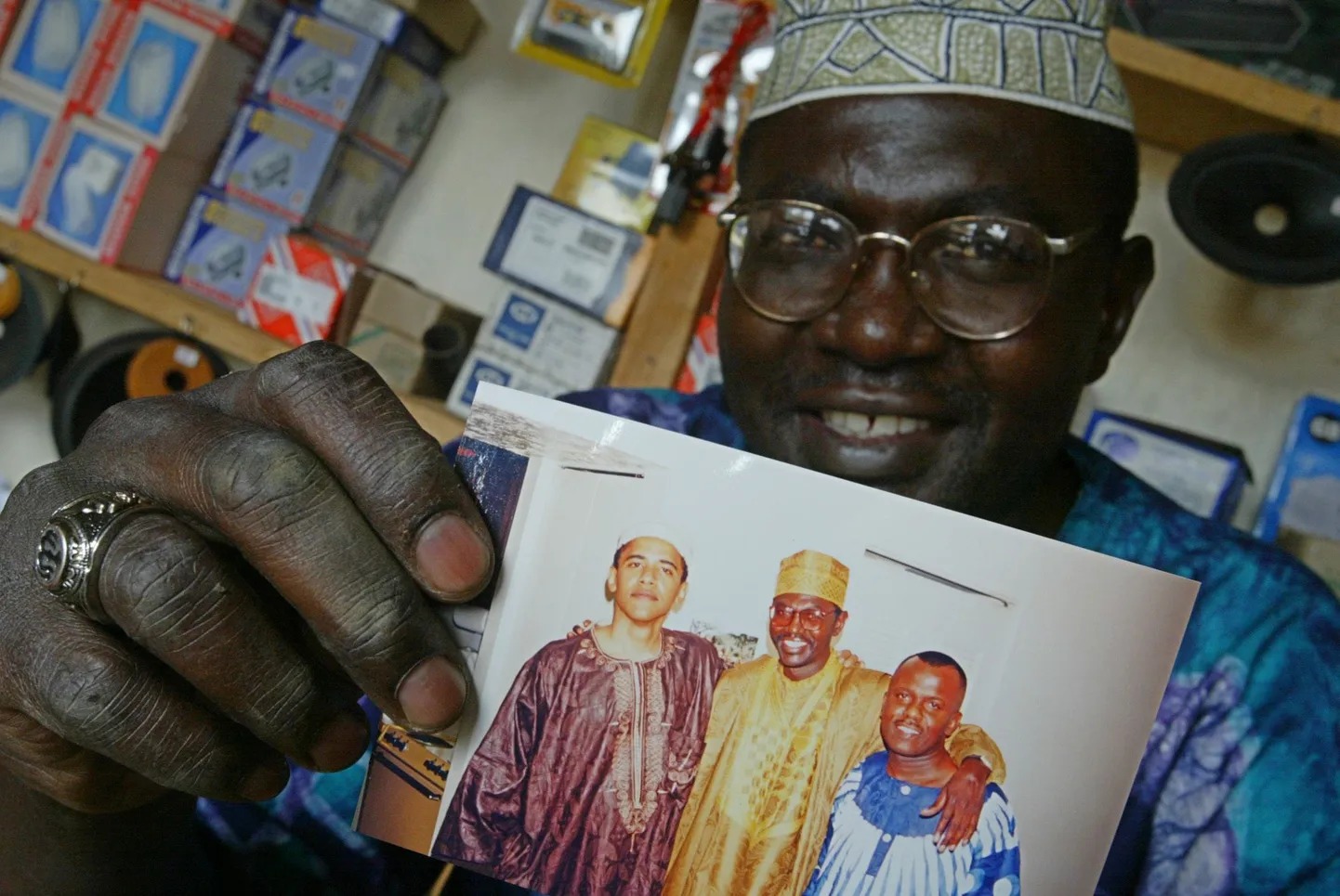 Malik Obama näitamas pilti, millel on Barack Obamat näha moslemirõivastes