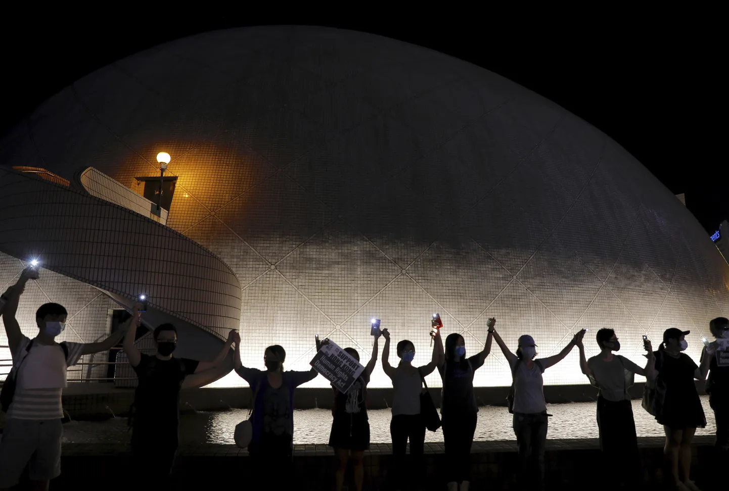 Demonstrators link hands as they gather at the Hong Kong Space Museum in Hong Kong, Friday, Aug. 23, 2019.