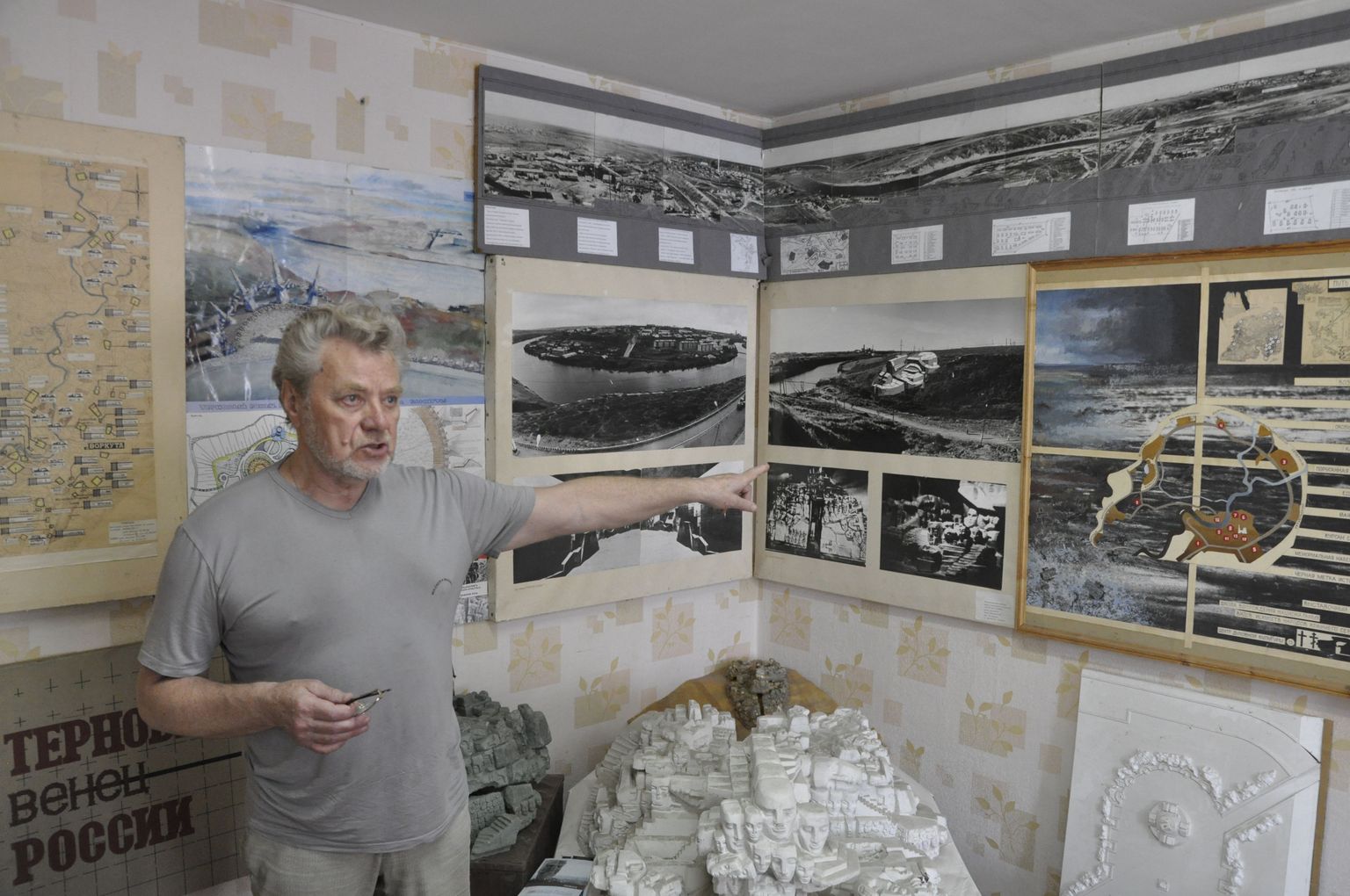 Vassili Trošin Vorkutas oma ateljees, mille kõik seinad on kaetud ajalooliste fotode ja erinevate mälestusmärkide eskiisidega.