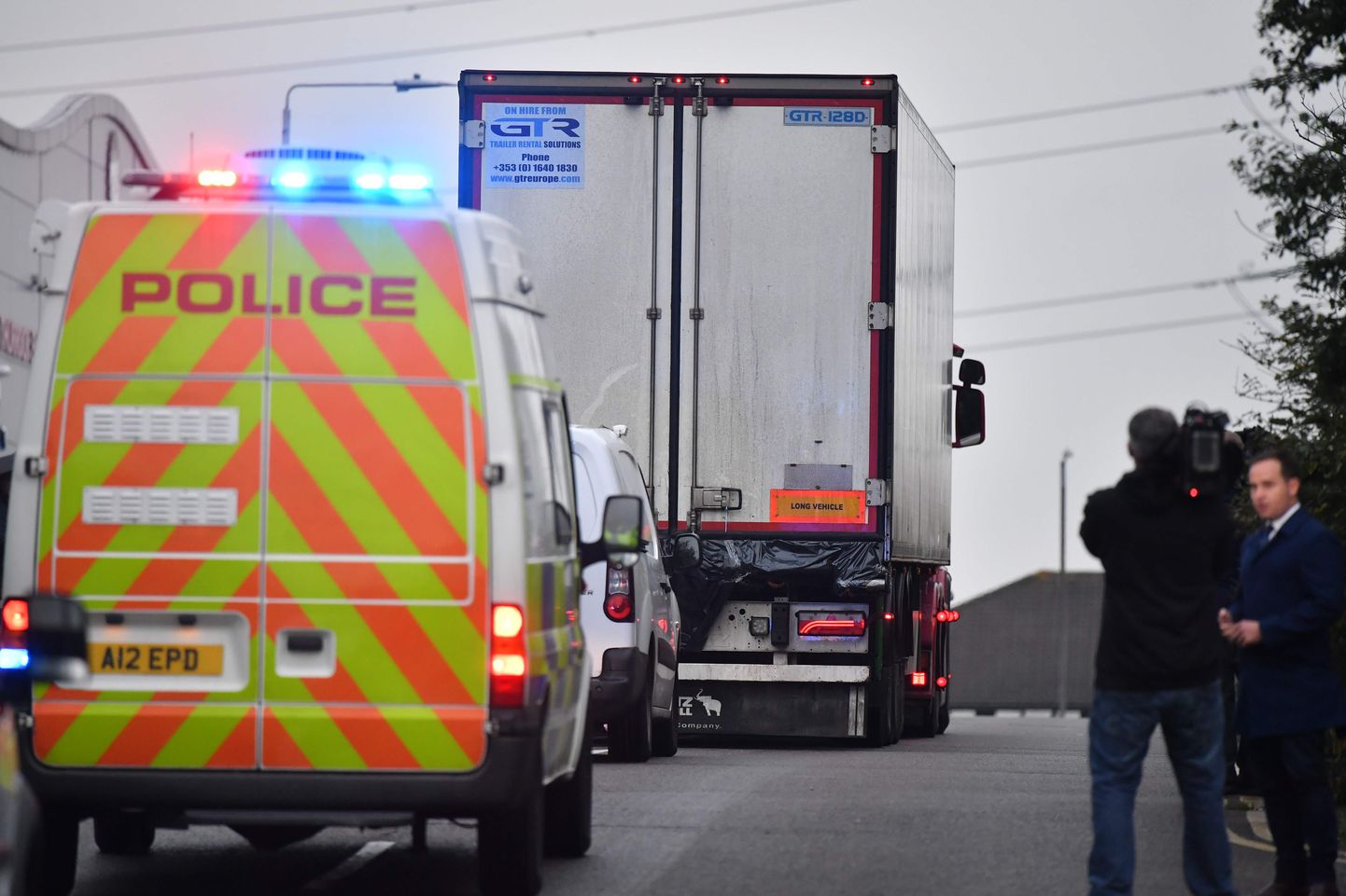 Lielbritānijas policija pārvieto kravas auto, kura konteinerā tika atrasti 39 cilvēku līķi.