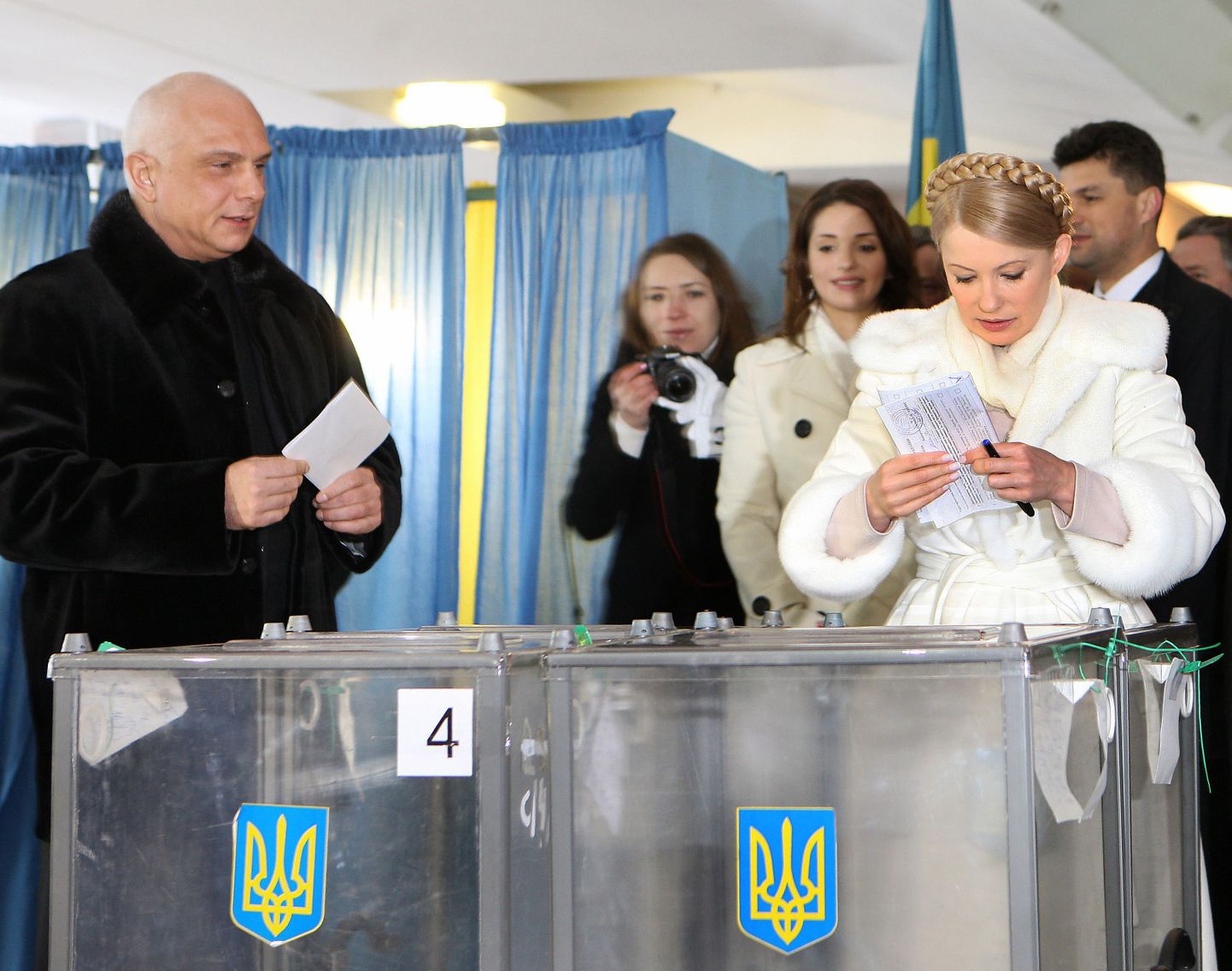 Oleksandr ja Julia Tõmošenko valimiskastide juures jaanuaris 2010. Taga paistab nende tütar Jevgenia (valges mantlis).