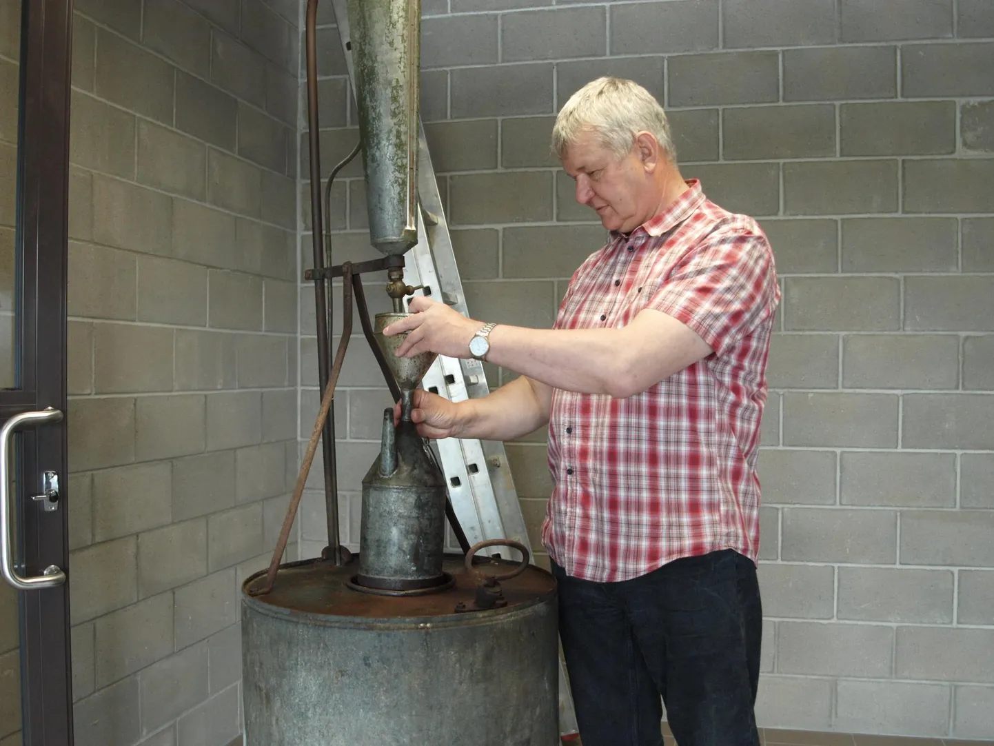 Lembit Kruuse demonstreerib uhkusega vana petrooleumitankurit.