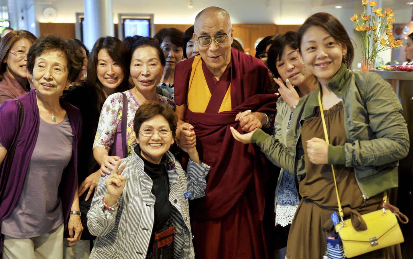 Tiiberi usujuht dalai-laama Helsingi Vantaa lennuväljal Jaapani turistidega tehtud ühispildi 18. augustil 2011.