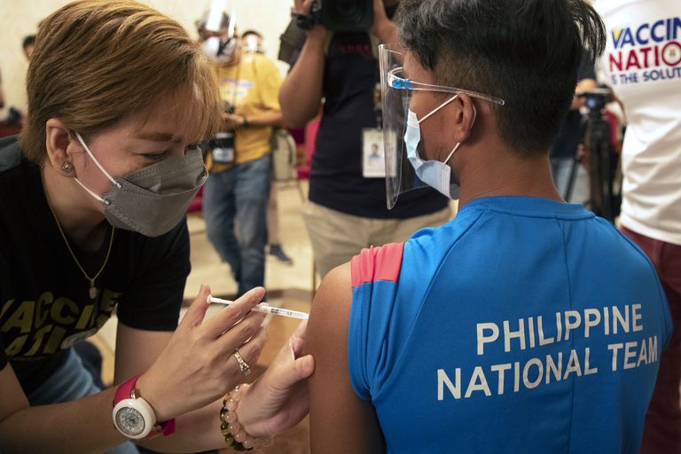 An athlete is inoculated with China's Sinovac COVID-19 vaccine at a hotel turned into a temporary vaccination center on Friday, May 28, 2021 in Manila, Philippines. Several Filipino athletes, coaches and other delegates were vaccinated Friday in preparation for their travel to the Tokyo Olympics and Southeast Asian Games in Vietnam. (AP Photo/Aaron Favila)