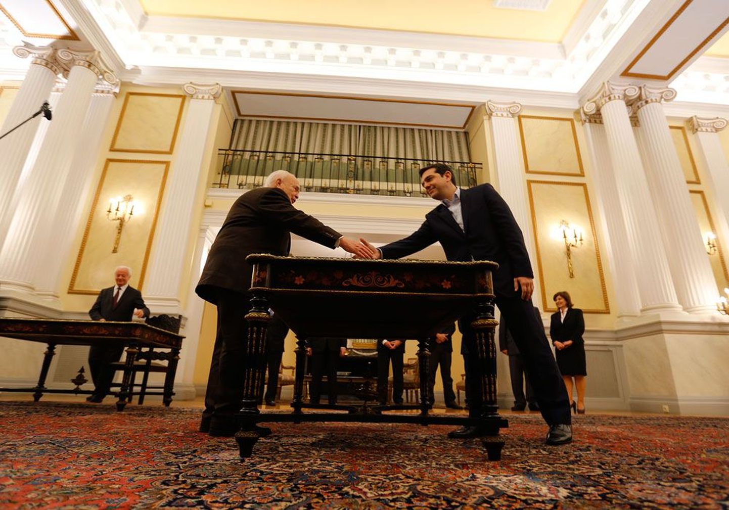 Алексис Ципрас (справа) первым из греческих премьеров принес гражданскую присягу в президентском дворце, нового главу правительства поздравил президент Каролос Папульяс (слева).