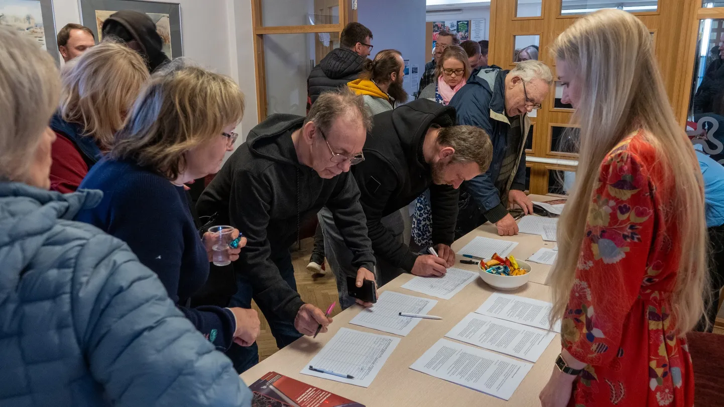 Märjamaa rahvakoosolekul osalejad annavad allkirju tuuleenergia vastu.