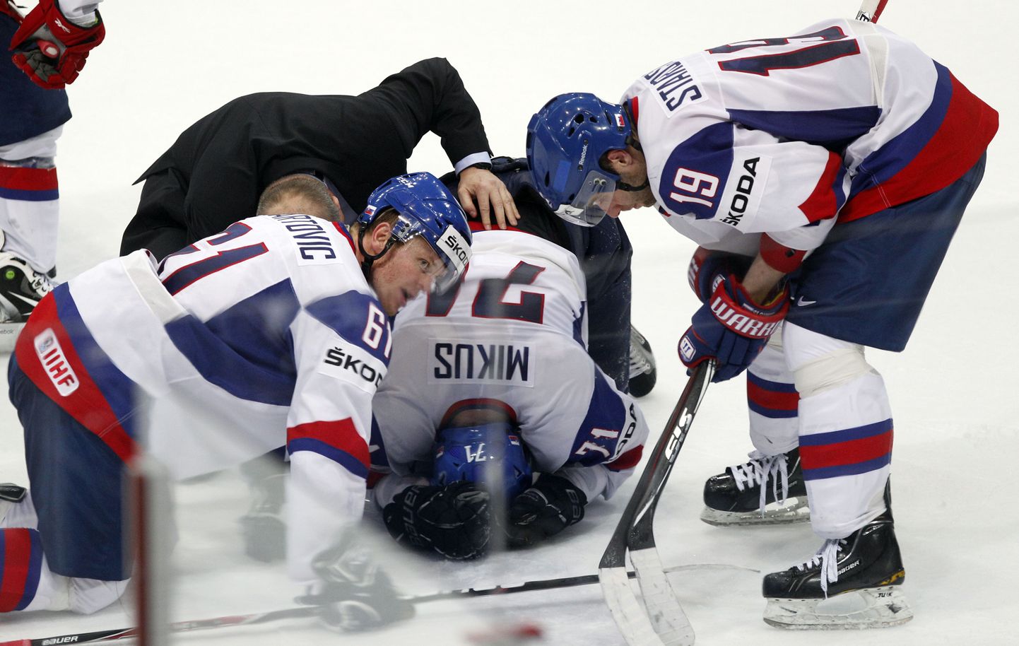 Юрая Микуш лежит на льду после столкновения.
