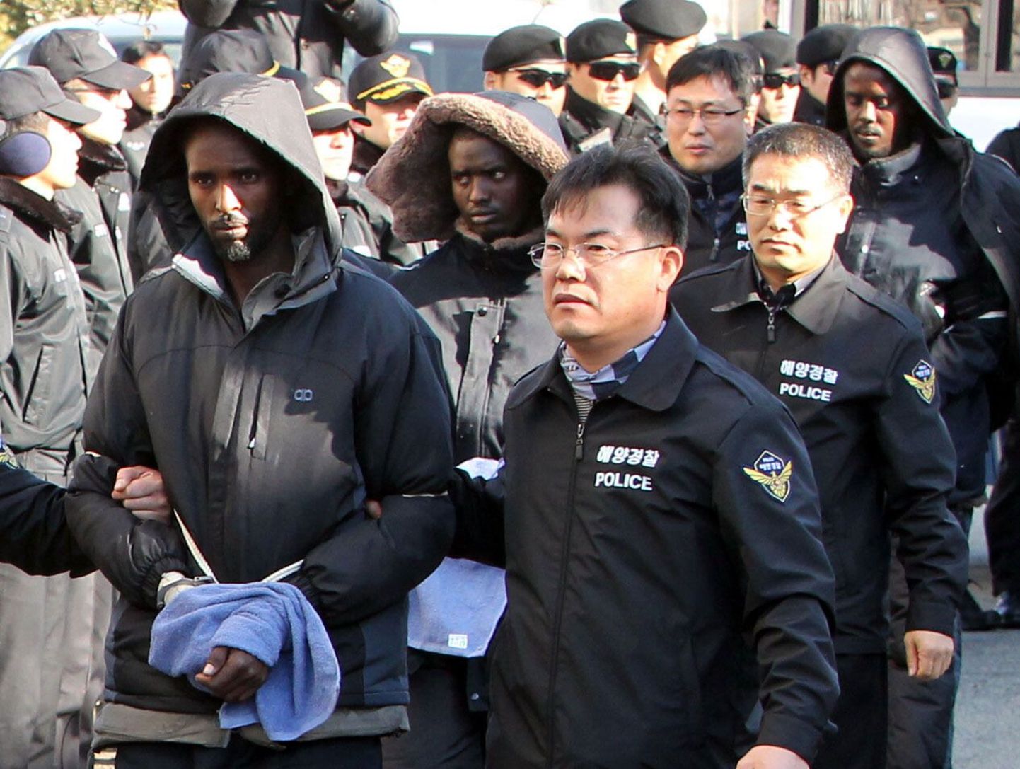 Lõuna-Korea politsei eskortimas Somaalia piraati.