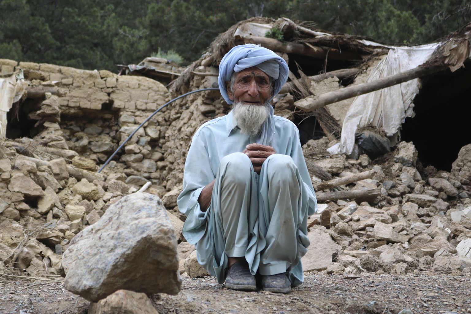 Khosti provintsis asuvast Spera piirkonnast pärit mees oma maavärinas hävinud kodu juures maas istumas.